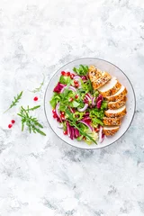 Fototapeten Grilled chicken breast, fillet and fresh vegetable leafy salad with arugula and pomegranate on plate © Sea Wave