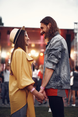 Happy relationship. Side view portrait of handsome bearded man holding hand of his charming girl