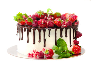 cake covered with berries of raspberry strawberry pomegranate mint leaves doused with chocolate on...