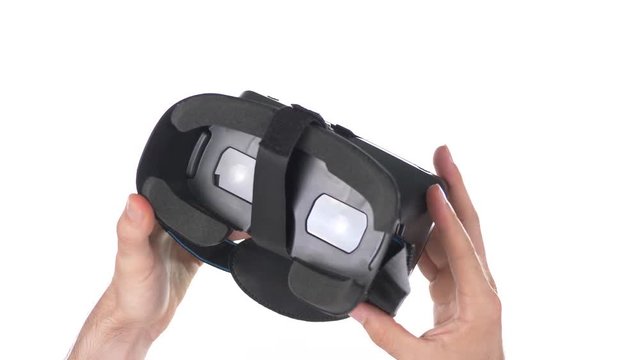 Virtual reality headset being handle in hands. White background