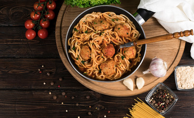 spaghetti and tomatoes on wooden background