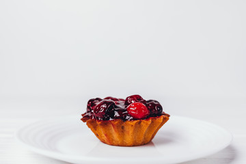 Delicious small tart decorated with red cherries