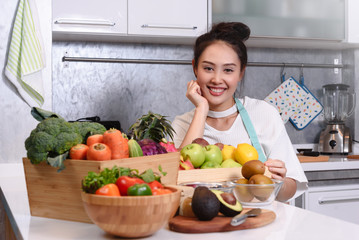Woman in kitchen with various kind of vegetable and fruits that all are good for health and no meat, vegan lifestyle