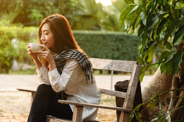 Naklejka premium Beautiful young teenage woman freelance have a cup of latte on sun light, freelance lifestyle conceptual