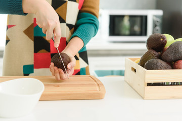 Young beautiful asian woman preparing avocado for breakfast in morning