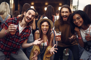 Portrait of happy hipster friends screaming with joy. Handsome bearded men holding beer