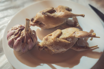 Pair of boiled quails lie on a white plate