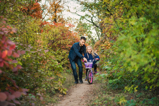 Father teach daughter how to drive bike