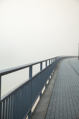 black bridge with paving stone in a fog