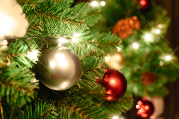 Fototapeta na wymiar Close up christmas tree decorated with christmas balls and light