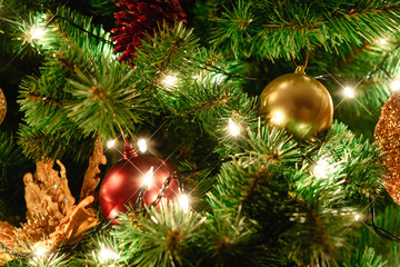 Obraz na płótnie Canvas Close up christmas tree decorated with christmas balls and light