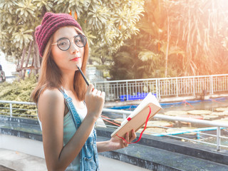 beautiful young Asia woman with reading book at outdoor garden.