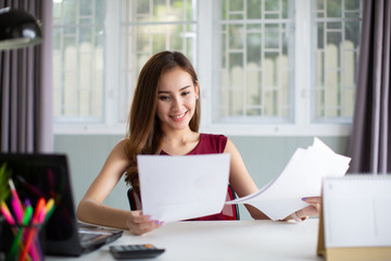 Beautiful young Asia woman working with laptop in her office