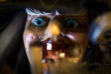 Toy evil witch with blue eyes. Traditional wooden design of a scary toothless sorcerer with a big...
