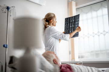 Side view portrait of beautiful young woman in white lab coat looking at results of magnetic...