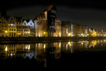 Fototapeta na wymiar Polska, Gdańsk - nocą na rzeką Motławą, oświetlona starówka i odbicia w wodzie