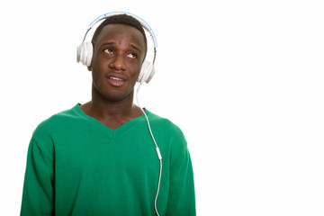 Young African man listening to music while thinking