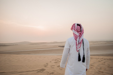 Arab man in the desert is meeting sunrise