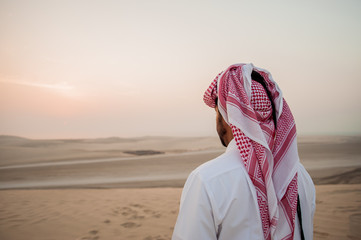 Arab man in the desert is meeting sunrise