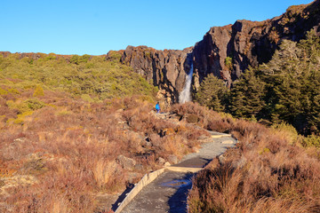 Fototapeta premium Tourist in front of waterfall in Tongariro National Park, New Zealand