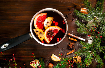 Christmas background. Hot mulled wine with ingredients in authentic ladle on wooden background. The...