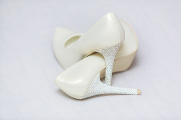 Elegant wedding shoes on white background.bridal shoes.  white high-heeled shoes. leather white shoes decorated with rhinestones.