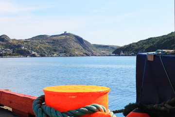 close-up of a mooring line tied to a bollard on the dock in St. john's Harbour, and looking beyond across the harbour toward Signal Hill.