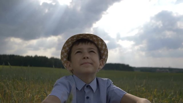 dreamer boy in the hat looks at the beautiful sky, outdoors