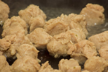 Pieces of soy meat are fried in a pan