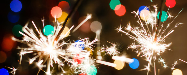 Bengal fire sparkler and colorful bokeh christmas new year background