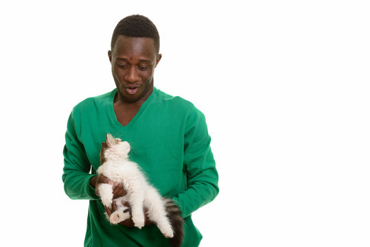 Young African man making funny face while holding cute cat
