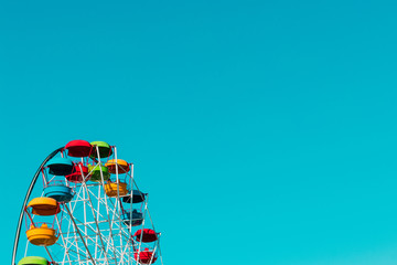 Multicolor ferris wheel over blue sky as background