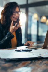 Documents on desk with women working at back