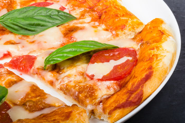 Slice of pizza with basil leaf