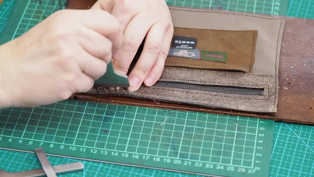 craftsman punches edge of pocket for handbag by stitching punch