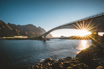 Sunrise and Sunset at Henningsvaer, fishing village located on several small islands in the Lofoten archipelago, Norway over a blue sky with clouds.