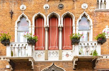 Fototapeta na wymiar tall windows on an old balcony with flowers in