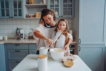 Obraz na płótnie Canvas mom teaches her little daughter to cook food