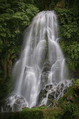 Fototapeta na wymiar Majestic waterfall in forest, Portugal. Ribeira dos Caldeiroes Nature Reserve at Achada, Nordeste, Azores
