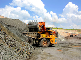 Excavator loads ore into dump truck