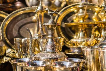 Fototapeta na wymiar A display of bright golden brass pitchers and trays