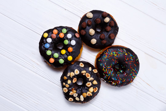 Delicious chocolate donuts with nuts over white background