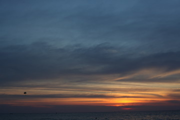 Naklejka na ściany i meble sunset on the sea, parachute, beautiful sky.