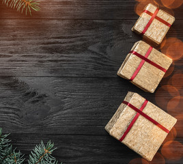 Wallpaper of winter holidays on black background. Side fir branches. Gold Gifts. Space for text....