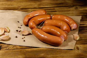 Sausages on brown paper on wooden table