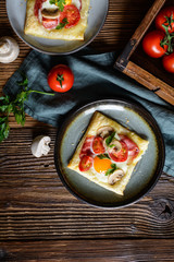 Puff pastry pies with egg, bacon, mushrooms and tomato