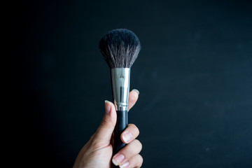 in the hands of a black makeup brush, the brush is located on thecenter, empty space for text
