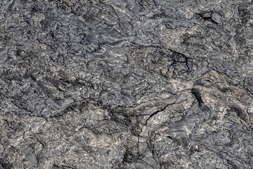 Aerial view of Puu Ooo Volcanic lava field. The pahoehoe lava's surface is swirled and wrinkled; it's smooth metalic surface reflecting. Giant cracks from cooling. On Hawaii's Big Island.