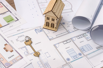 Wooden house model and key on house plan drawing