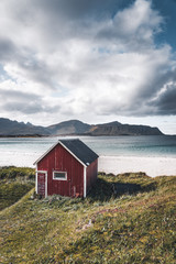 A typical house of the fishermen called rorbu on the beach frames the sea at Ramberg Lofoten Islands, Norway Europe